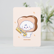 Load image into Gallery viewer, A cute mini art print featuring Bibo the dog character with his head inside a slice of bread, holding a stick of 'Bibo Butter' on a soft cream background