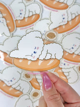 Load image into Gallery viewer, Sticker of a fluffy white dog on an orange plate held over a sheet of similar stickers.