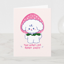 Load image into Gallery viewer, A charming greeting card with Bibo wearing a large strawberry as a hat, surrounded by sparkles and the text 'You Make Life Berry Sweet' on a light pink background.