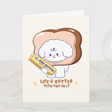 Load image into Gallery viewer, A cute and punny greeting card featuring Bibo the dog with his head inside a slice of bread, holding a stick of Bibo Butter, with the text 'Life's Butter With You In It'