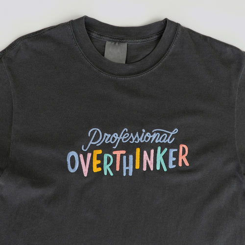 A graphite grey, 100% cotton t-shirt with a playful, embroidered message that reads 